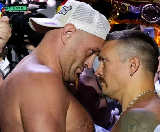 Tyson Fury and Oleksandr Usyk face off in the boxing ring, capturing the intensity and anticipation of the fight.